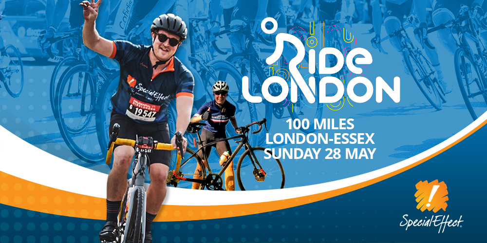 Smiling cyclist wearing SpecialEffect top raising his hand