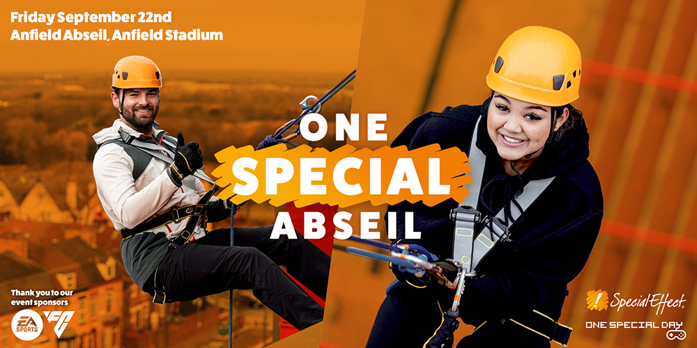 Smiling man and woman in safety hats looking up while abseiling
